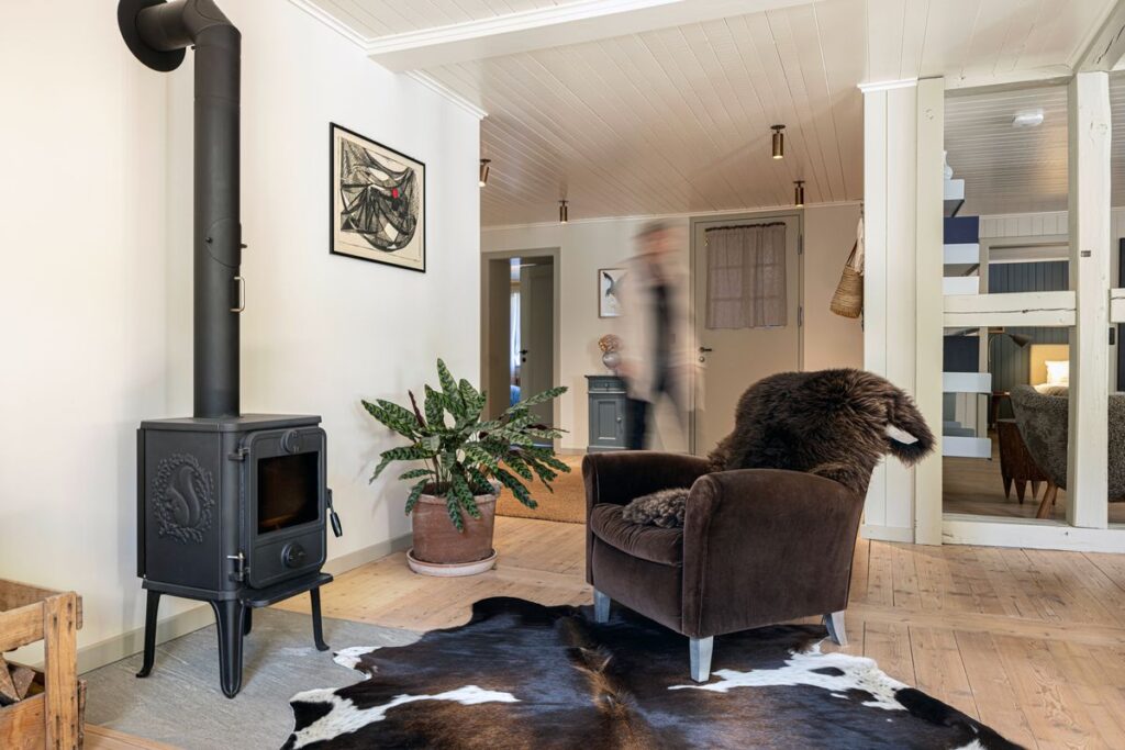 Kuhfell Teppich im Wohnzimmer vor Holzofen mit Sessel und Fell – Fell-shop.ch