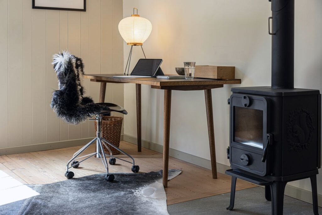 Home Office mit tibetischem Lammfell naturgrau auf dem Bürostuhl und Kuhfell auf dem Boden – fell-shop.ch